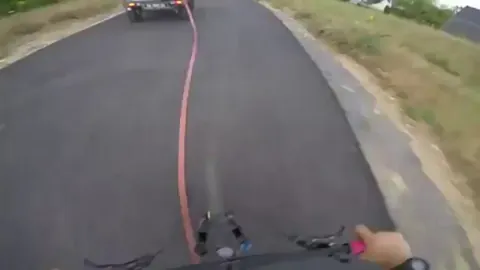 Speeding cyclist jumps over an entire car .