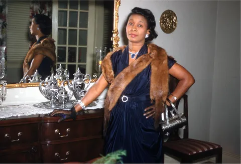 Lady posing proudly and dressed in her finery ready to go out, kodachrome 1950s.