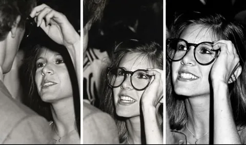Carries Fisher trying on Peter Weller's glasses during Giorgio Armani fashion show (1980)