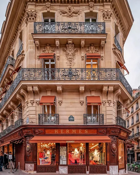 Corner facade of a Haussmann building with mahogany-rimmed windows and pink Haumont marble bases, Place Paul-Émile-Victor, 8th arrondissement of Paris, France.