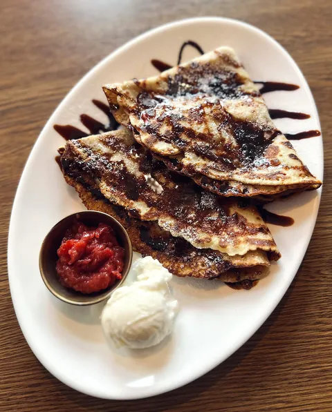 Crepes, ice cream, jam and chocolate sauce