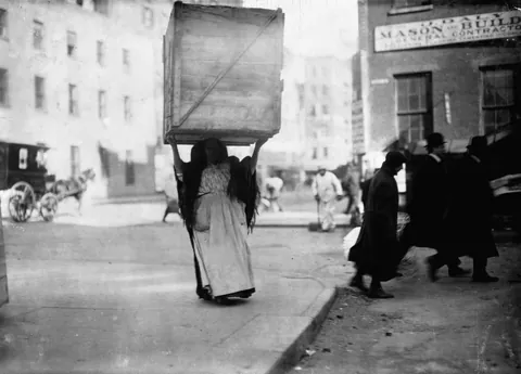 Italian woman carring box of dry goods in New York, February of 1912. Photo by Lewis Hine.