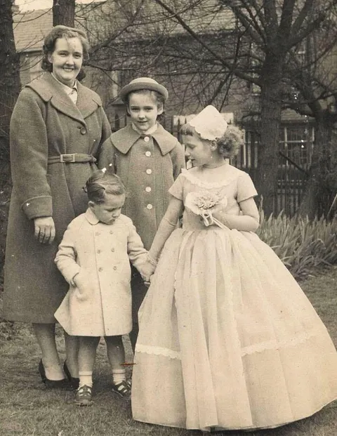My nana in the huge frilly dress with her mother and cousins. circa 1950s I believe?
