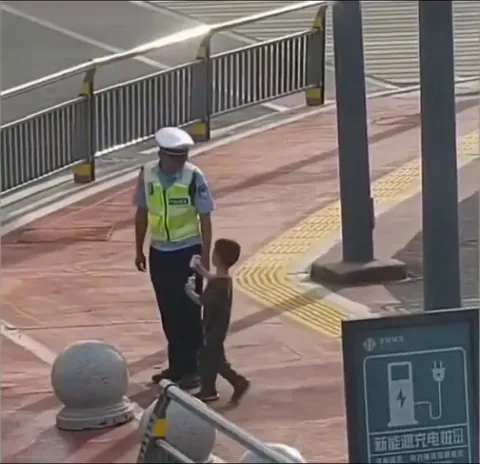Kid thanks a traffic constable with a juice pack and a salute