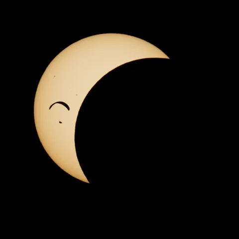 Paraglider in front of partial solar eclipse
