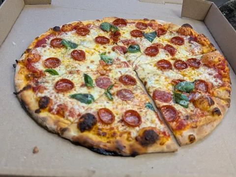 [Pro/chef] Pepperoni and basil pizza out of the brick oven