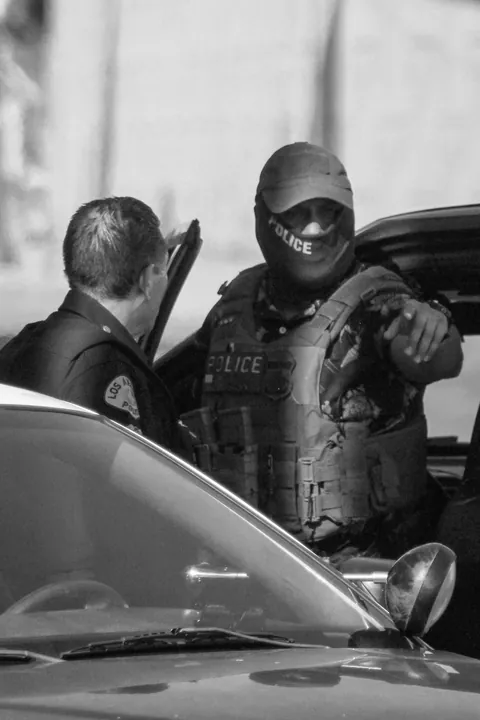 LAPD won’t enforce mask ban; here’s ICE in a POLICE mask, lounging on an LAPD car during arrest [OC]