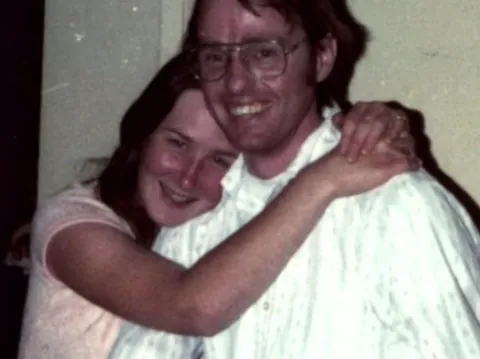 This is a photo of Colleen Stan with Cameron Hooker, the man who kidnapped and held her captive for seven years. It was photographed when she had been allowed to visit her parents for the first time, and it was actually photographed by her dad.