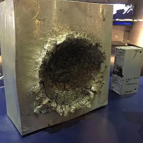 A tiny 3.6mm aluminum ball slammed into a solid aluminum block at 6,860 m/s (over 15,000 mph) - this is the kind of damage even the smallest piece of space debris can cause.