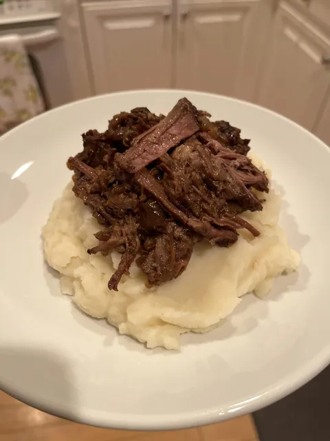 Homemade braised beef over mashed potatoes.