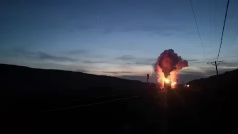 A steam locomotive ejecting cinders