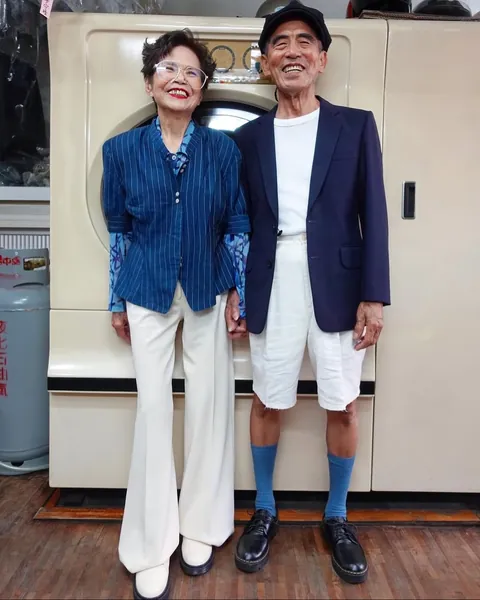 Taiwanese couple wear clothes that were left behind at their laundromat.