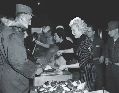 Marilyn Monroe working in the kitchen serving food for the troops in Korea, February of (1954)