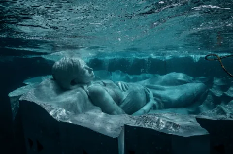 "Ocean Gaia", Japan's first underwater sculpture, weighing over 45 tons and 5.5 meters wide, created by British sculptor Jason deCaires Taylor, featuring Japanese model Kiko Mizuhara, resting 5 meters below the surface off the island of Tokunoshima, Japan, installed on October 14, 2025