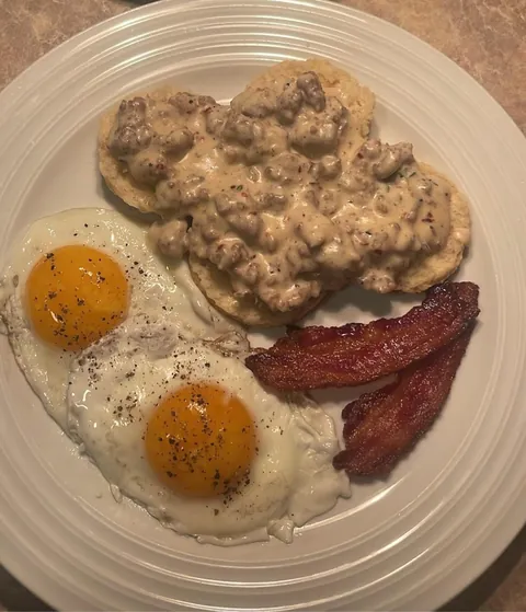 [homemade] buttermilk biscuits and gravy with sunny side up eggs and bacon