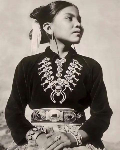 Navajo girl wearing silver and turquoise Squash Blossom jewelry, 1950.