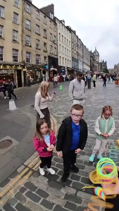 A man doing slinky tricks for his audience