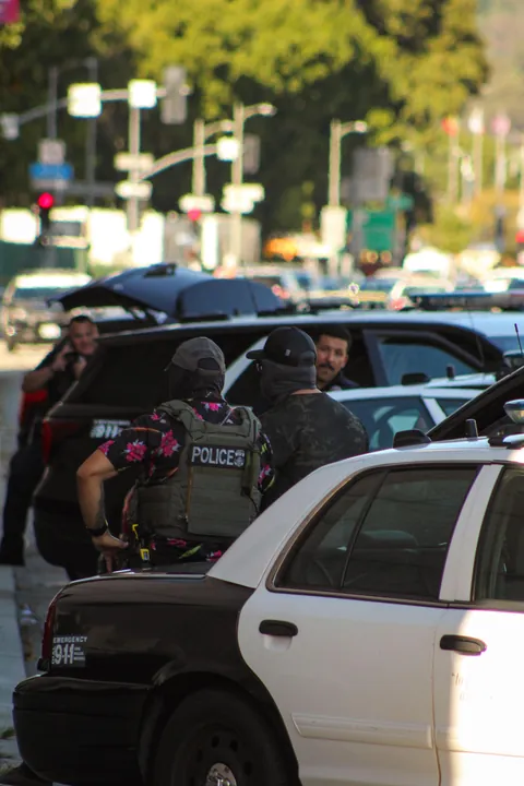 LAPD won’t enforce mask ban; here’s ICE in a POLICE mask, lounging on an LAPD car during arrest [OC]