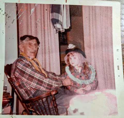 1975 hanging out with Grandpa, wearing plastic party leis and one of Grandma's fancy old hats.