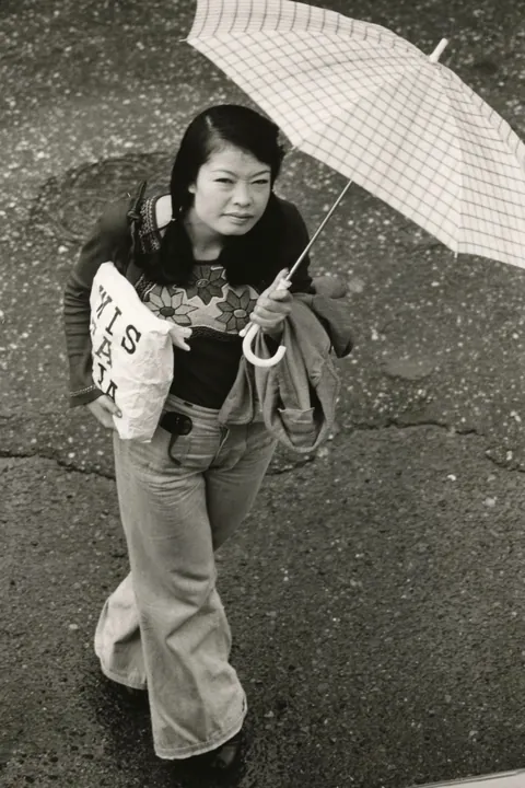 In 1974, Masahisa Fukase photographed his wife, Yōko Wanibe, every morning from the window of their apartment in Tokyo as she left for work.