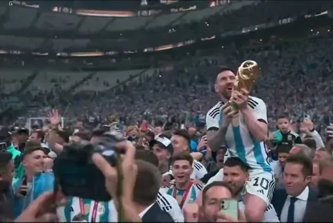 Lionel Messi being carried on Sergio Aguero's shoulders whilst lifting the World Cup trophy