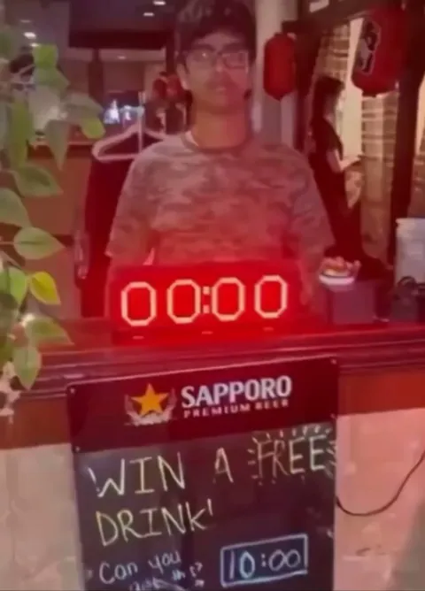 Guy wins a free beer by stopping the clock at exactly 10:00 seconds.