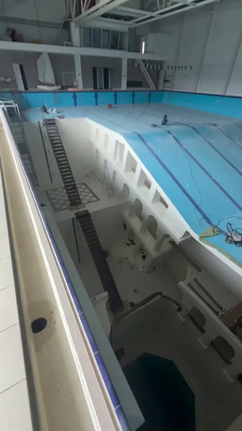 A very deep indoor pool with multiple levels emptied for maintenance
