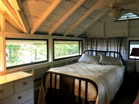 Best bed in my family's lake cottage, surrounded by three walls of windows. 