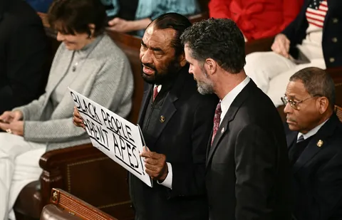 Al Green escorted out for second consecutive year, with a sign saying 'Black people aren't apes'