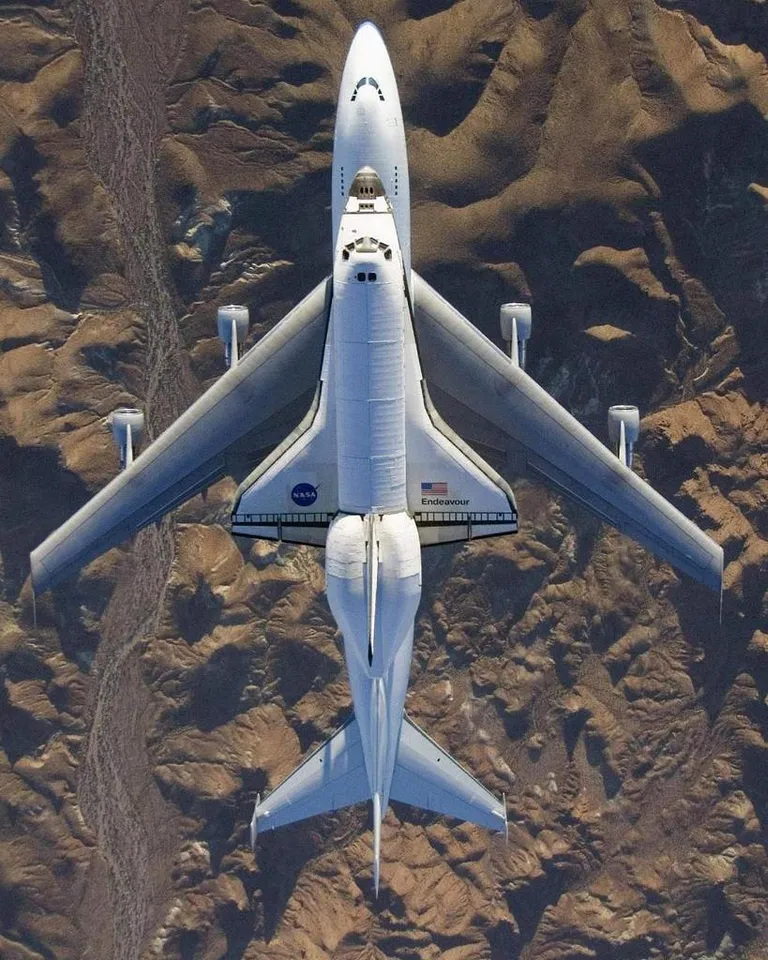 Bird's-eye view looking down on Space Shuttle Endeavour as it flies over the Mojave Desert on the back of a Boeing 747