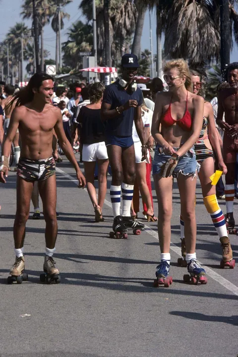 Venice Beach California during the late 1970s roller skate craze. Still has some 70s vibe but you can feel the 80s coming.