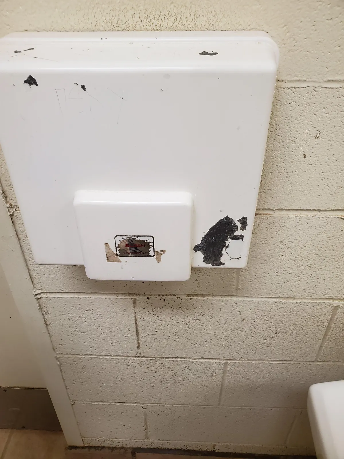 At the zoo. Chipped paint on hand dryer looks like bear drying it's hands.