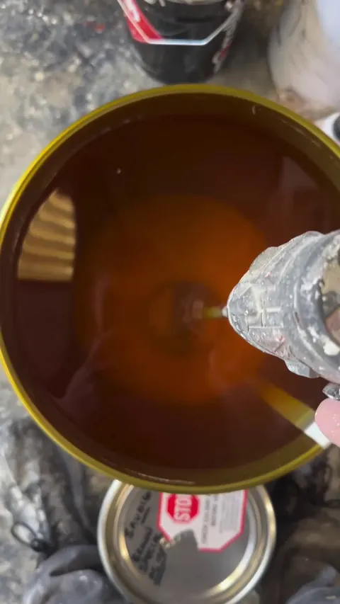 Stirring a drum of wood lacquer that’s been sitting for a while