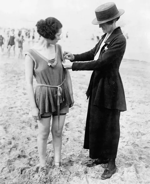 Women getting arrested due to improper bathing suit measurements, 1920s.