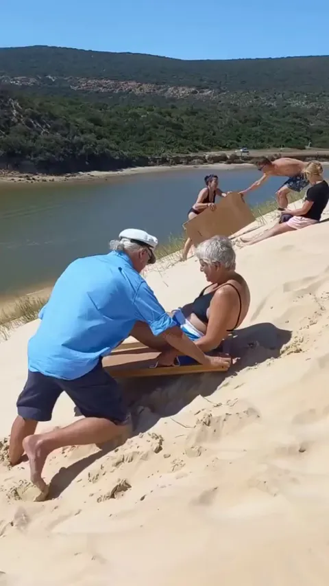 Bye Nana! - sledding down a sand bank into the water