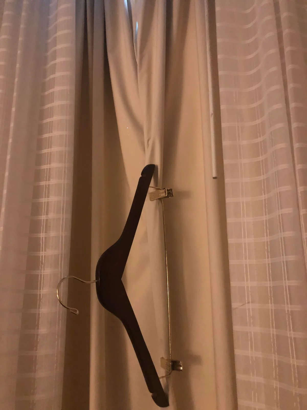 Hotel curtains letting in too much light?? Grab a hangar with clips and pinch it shut.