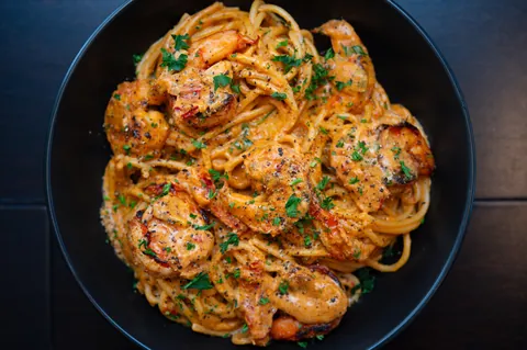 [homemade] blackened grilled shrimp, sun-dried tomato pesto, garlic and Parmesan pasta. 