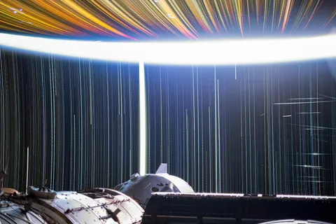 Star trail time exposure from the ISS, with Moon, satellites, cities, and stars.