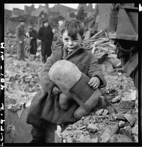 Little boy hugs his plush toy after the blitz, London, England, 1940-41