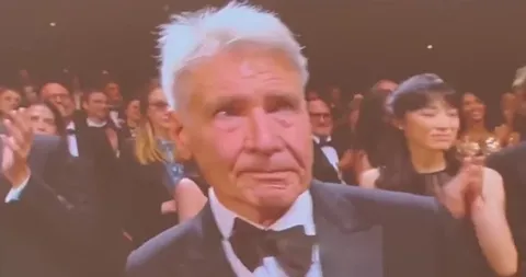 harrison ford holding back tears as he receives a 5 minute standing ovation during the premiere of 'indiana jones and the dial of destiny'