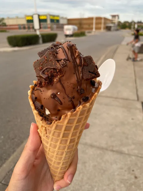 [I Ate] Vanilla soft serve covered in real milk chocolate and brownies, in a fresh waffle cone