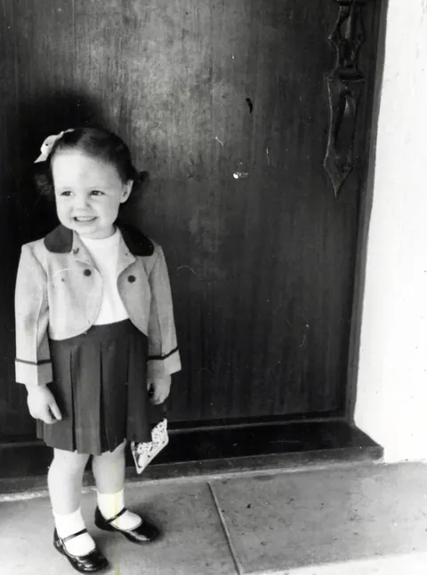 Posing for my grandmother in my fancy new suit. 1957