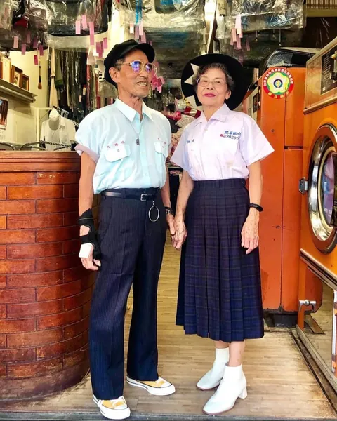 Taiwanese couple wear clothes that were left behind at their laundromat.