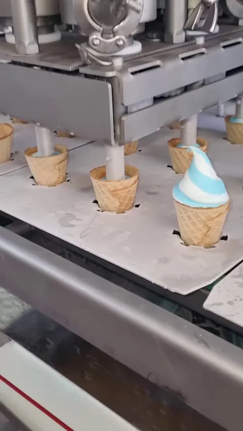 An ice cream machine filling waffle cones one after another