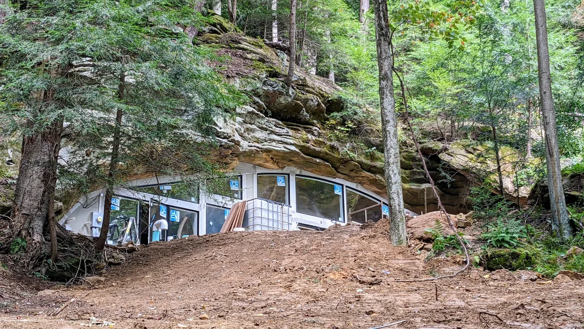 Is building under a huge rock like this safe? My first thought when I say this was earthquakes.
