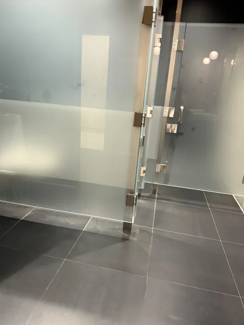 The men’s restroom at a car dealership has almost clear toilet stalls