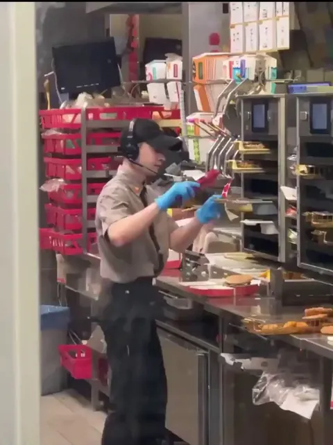 Fast food worker caught spitting in a burger