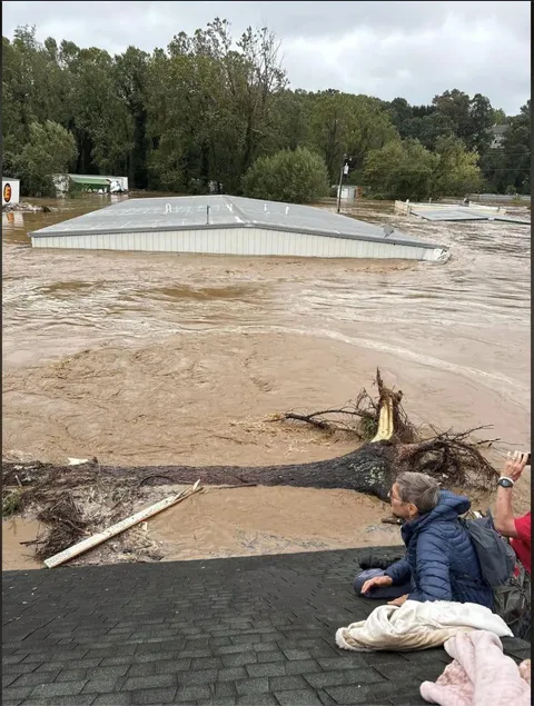 Last image of a couple &amp; their granddaughter in Asheville, NC sheltering from the flood on a roof.