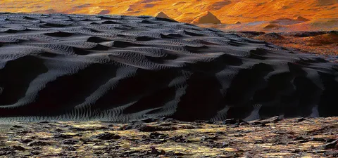 Black Sand Dunes on Mars taken by NASA’s Curiosity Rover, most sand on Earth is made from the mineral quartz, which is white and bright. On Mars, most sand is composed of dark basalt, a volcanic rock.