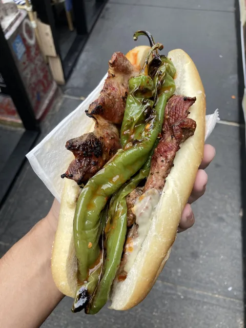 [I ate] this “braciole” sandwich of grilled pork, cheese, long hots, and hot sauce